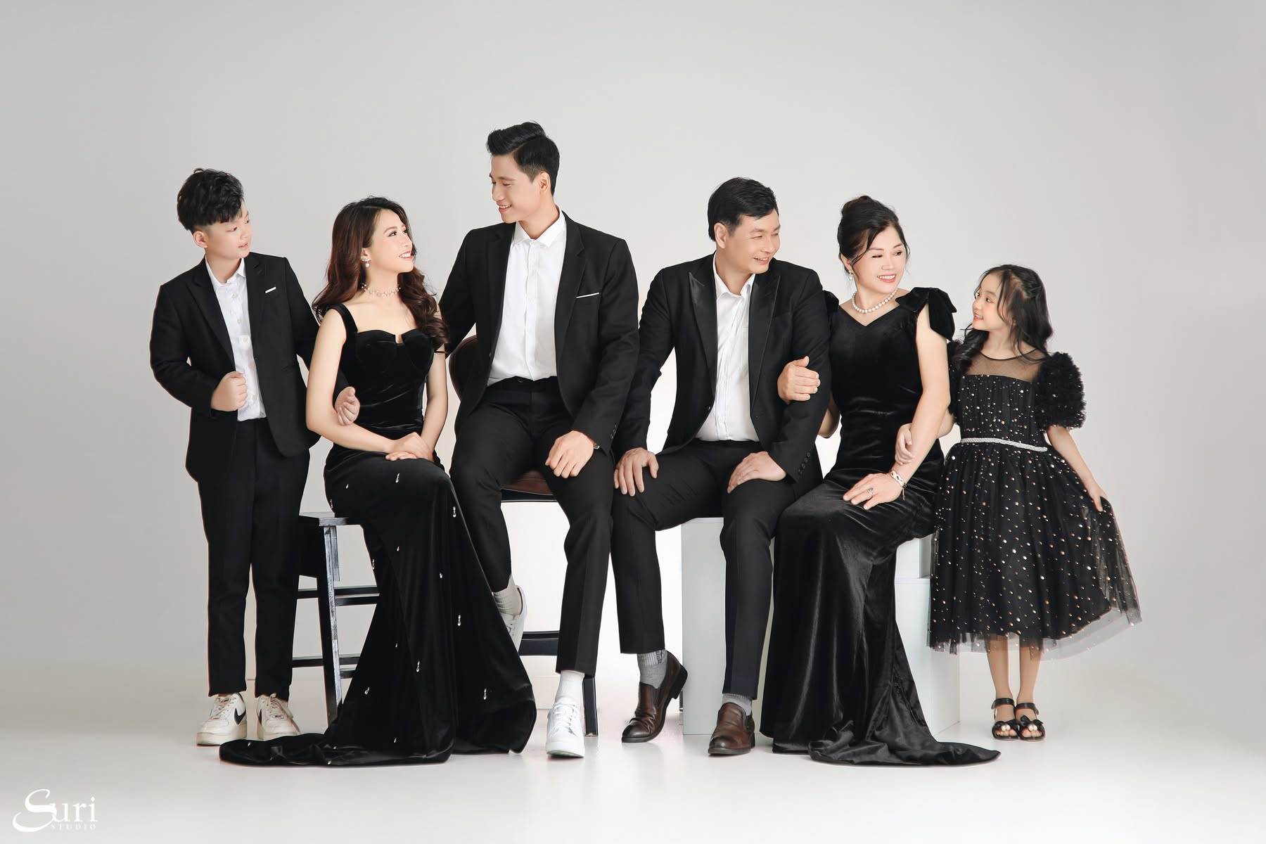 Ông bà ngồi cùng con cháu mặc nhung đen