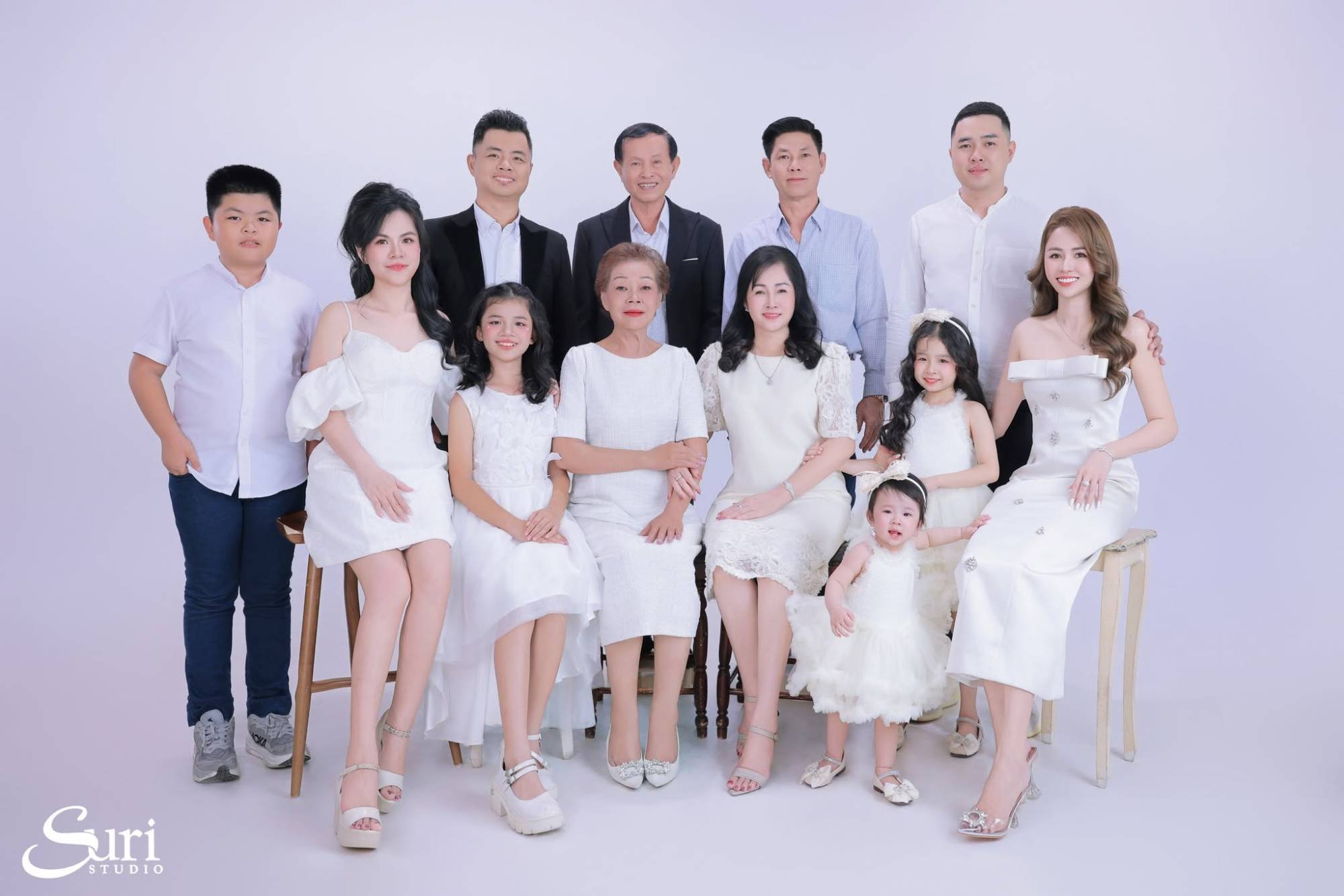 Đại gia đình 13 người ba thế hệ mặc đồ trắng, ông bà ngồi giữa